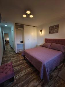 a bedroom with a large bed with a purple bedspread at Cabañas Bosque marino in Pichilemu