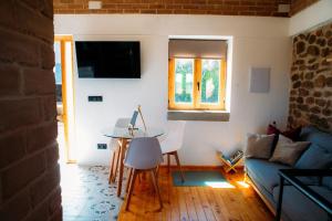 a living room with a table and a couch at Bodega Ecológica - Rioja Suites in Tudelilla