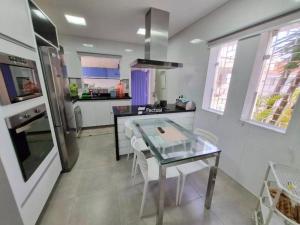 a kitchen with a table and a counter top at Casa Enseada Guarujá in Guarujá +11 photos