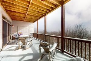 a screened porch with chairs and a table at Reserve 02-D in Sugar Mountain