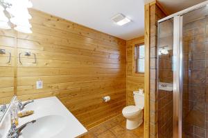 a bathroom with wooden walls and a toilet and a sink at 5 Little Acorns in McHenry +30 photos