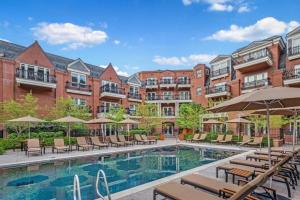 ein Hotelpool mit Liegen und Sonnenschirmen in der Unterkunft Aspen Mountain Residences 2 Bedroom Luxury Residence in Aspen