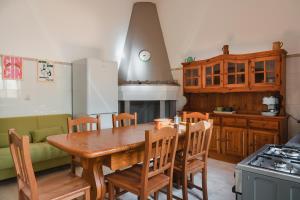 y cocina con mesa de madera, sillas y fogones. en Dimora Teresa, en San Pietro Vernotico 25 fotos más