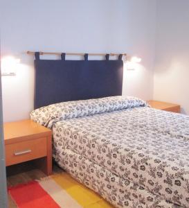 1 dormitorio con cama y mesita de noche de madera en Apartamentos Legazpi, en Cangas del Narcea