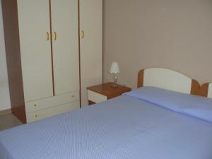 a bedroom with a blue bed and a dresser at Central Palace Malfà in Scoglitti