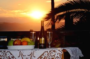 a table with a bowl of fruit and a bottle of wine at Maria Studios in Neo Klima