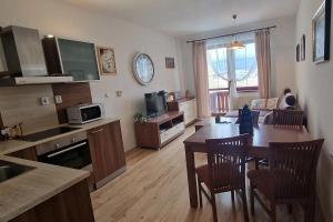 a kitchen and living room with a table and chairs at Apartmán Martius Veľká Lomnica in Veľká Lomnica