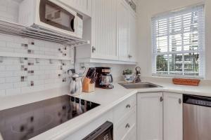a white kitchen with a sink and a microwave at Classic Quarters at the 101 in Savannah