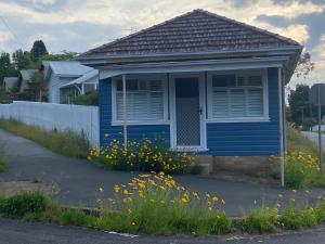 ein blaues Haus mit Blumen davor in der Unterkunft Katoomba Cosy Cottage- entire 65sqm cottage in Katoomba + 8 Fotos