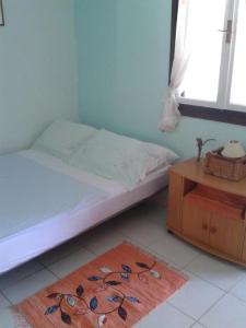 Un dormitorio con una cama y una mesa y una ventana. en House More, en Maslinica