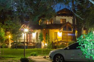 a white car parked in front of a house at night at Blumenau Relax & Holidays in Villa General Belgrano