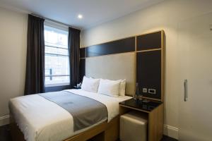 um quarto de hotel com uma cama e uma janela em The Z Hotel Gloucester Place em Londres