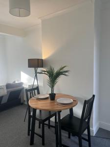 ダートフォードにある2Bed Sleeps 3 - Central Near Train Station Wifiのダイニングルーム(椅子、鉢植えの植物付)