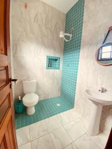 un baño con inodoro y lavabo en Íkaia Surf House, en Ubatuba