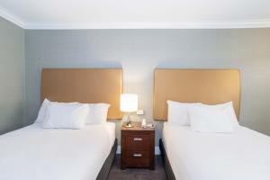 two beds sitting next to each other in a hotel room at Sandman Hotel Vernon in Vernon