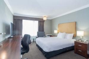 a hotel room with a bed and a desk at Sandman Hotel Vernon in Vernon +61 photos