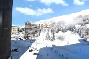 a view of a snow covered mountain with a building at Appartement charmant à Les Menuires, 36 m², vue montagne. in Saint-Martin-de-Belleville +5 photos