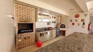 a kitchen with a fireplace and a brick wall at 3 bedrooms with heated pool Temporada Brasilia in Brasilia