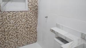 a bathroom with a white counter and a brick wall at Casa do 40 horas in Ananindeua