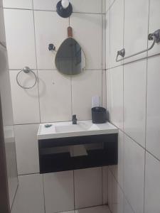 a white bathroom with a sink and a mirror at Residência Dazzi in Rio de Janeiro