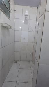 a bathroom with a shower with white tiled walls at Residência Dazzi in Rio de Janeiro