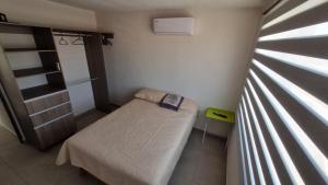 a small room with a bed and a window at Casa Acapulco Playa Bonfil in Acapulco +10 photos
