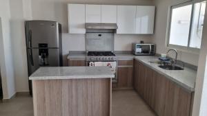 a kitchen with a stove and a refrigerator at Casa Acapulco Playa Bonfil in Acapulco