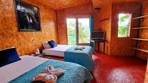 a room with two beds and a tv and windows at Refugio Ecolodge Shapingo in Moyobamba +64 photos