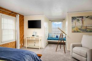 a bedroom with a bed and a tv and a couch at Surf and Sand Dollars in Seaside