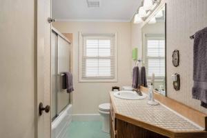 a bathroom with a sink and a toilet and a mirror at Surf and Sand Dollars in Seaside +42 photos