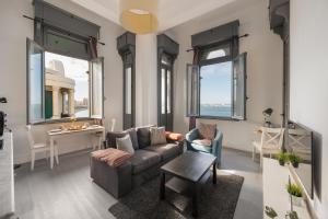 a living room with a couch and a table at grey l studio apartments Corniche Alexandria Little Venice in Alexandria