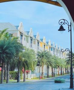 a row of houses with palm trees on a street at Welcome to Ho Tram Villa in Xuyên Mộc