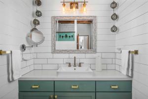 un baño con lavabo y espejo en The Little Sand Castle, en Rockaway Beach 40 fotos más