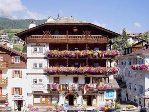 a large building with flower boxes on it at Post Hotel Moena in Moena
