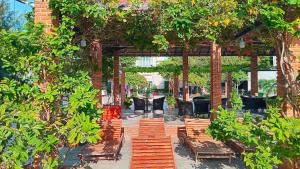 un'area salotto all'aperto con sedie e alberi di Red Coral Hotel a Phan Rang-Tháp Chàm