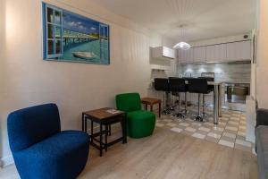 a living room with chairs and a table and a kitchen at Appt rez de jardin 6 personnes avec piscine tennis et parking gratuit 21 in Le Touquet-Paris-Plage