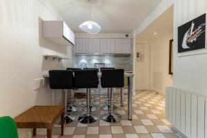 a kitchen with a table and some black bar stools at Appt rez de jardin 6 personnes avec piscine tennis et parking gratuit 21 in Le Touquet-Paris-Plage