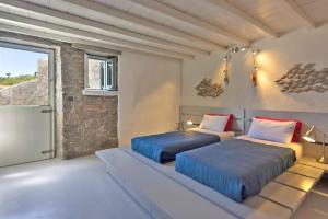 two beds in a room with a window at Villa Ananda Mykonianvilla in Panormos Mykonos +38 photos