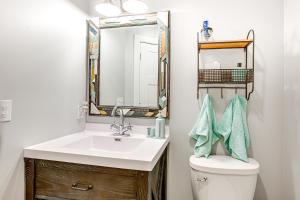 a bathroom with a sink and a toilet with a mirror at Charming Bear Lake Cottage with Dock and Paddleboards! in Bear Lake +16 photos