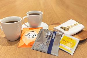 a table with a cup of coffee and a book at HOTEL MYSTAYS PREMIER Kanazawa in Kanazawa