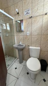 a bathroom with a toilet and a sink at Kitnet Praia Grande in Arraial do Cabo