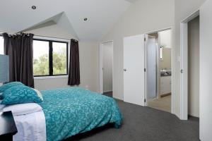 a bedroom with a bed and a large window at Mt Maunganui White House in Mount Maunganui