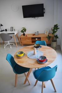 a wooden table with blue chairs in a living room at Ecoloft Estudios in Cartagena