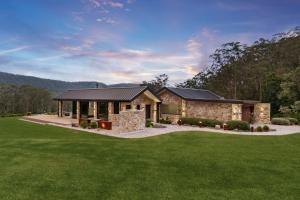 BarrengarryにあるVilla Arbosana, Barrengarry, Kangaroo Valleyの緑の芝生の石造りの家