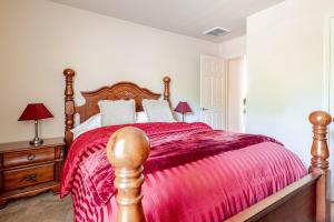 a bedroom with a wooden bed with a red blanket at Nice big house in Woodlands area in Spring