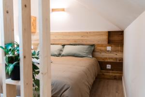 a bed in a small room with wooden walls at - Apparts nets à prix honnête - in Brest