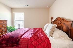 a bedroom with a bed with a red and white blanket at Nice big house in Woodlands area in Spring