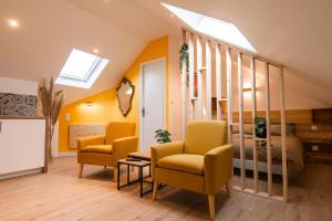 a living room with two chairs and a bed at - Apparts nets à prix honnête - in Brest