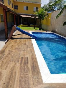a pool with a water slide in a yard at Casa Vale da Paz - Massaguaçu. in Caraguatatuba