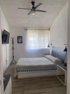 a bedroom with a bed with a ceiling fan at DEPA IXTLAN alberca y cerca de playa in Santa Cruz Huatulco